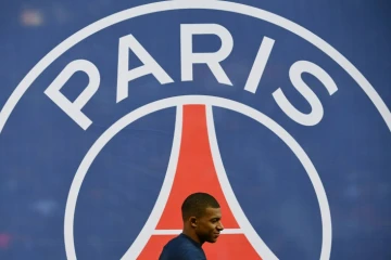 L'attaquant du PSG Kylian Mbappé passe devant le logo du PSG, le 23 février 2019 au Parc des Princes