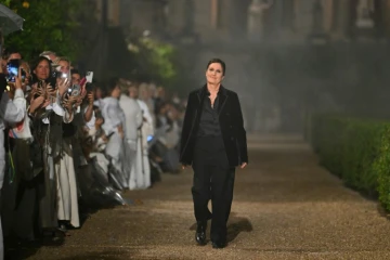 Maria Grazia Chiuri (c), directrice artistique de Dior, salue le public à la fin du défilé de la collection Dior Femme Croisière 26 à la Villa Albani Torlonia, à Rome, le 27 mai 2025