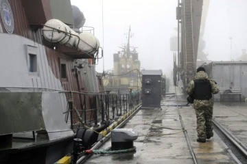 Un soldat ukrainien patrouille près de navires militaires au mouillage dans le port de Marioupol, le 27 novembre 2018 en Ukraine