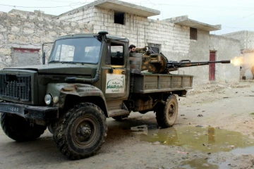 Un rebelle du groupe islamiste Ahrar al-Sham, faisant partie d'une coalition de groupes rebelles, tire sur des positions des forces gouvernementales syriennes près d'Alep, le 27 janvier 2014