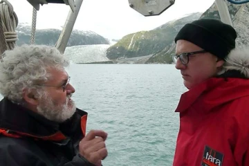 Les responsables de l'expédition "Tara-Océans", Etienne Bourgois (D), propriétaire de la goélette et le biologiste Eric Karsenti, devant le glacier Pia et la péninsule de Patagonie (Chili), le 4 février 2011