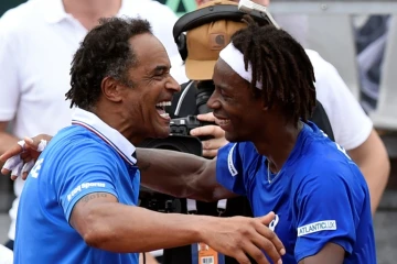 L'entraîneur Yannick Noah (g) congratule Gaël Monfils après sa victoire contre le Canadien Frank Dancevic en Coupe Davis, le 4 mars 2016 à Baie-Mahault (Guadeloupe) 