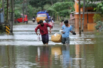 Des Indiens transportent de la nourriture et de l'eau pour les déplacés des inondations, dans le district d'Alappuzha, dans l'état indien du Kerala, le 21 août 2018