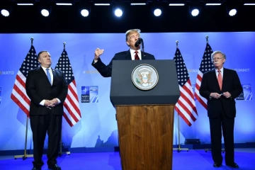 Le président américain Donald Trump entouré de son secrétaire d'Etat Mike Pompeo et de son conseiller à la Sécurité nationale John Bolton, lors de sa conférence de presse à l'issue du sommet de l'Otan à Bruxelles le 12 juillet 2018.