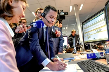 Le ministre des Comptes publics Gérald Darmanin parle avec un contribuable au téléphone depuis le centre des impôts d'Amiens, le 2 janvier 2019