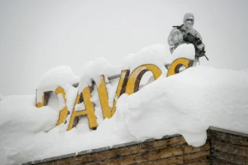 Un membre du service de sécurité, en tenue de camouflage, monte la garde sur le toit d'un hôtel à Davos (Suisse) le 22 janvier 2018
