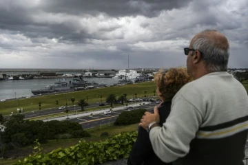 Un couple regarde un bateau militaire à son retour dans le port de Mar del Plata après ses recherches du sous-marin argentin San Juan, le 20 novembre 2017   