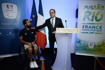 Le porte drapeau de la délégation française aux Jeux paralympiques à Rio, Michael Jeremiasz (g) lors du discours du président François Hollande (d), le 1er septembre 2016 à Paris   