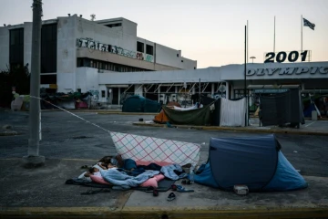 Des migrants dorment près de l'aéroport international d'Athènes le 10 août 2016