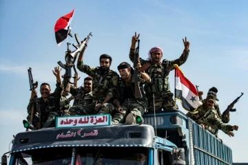 Des membres des forces gouvernementales syriennes arrivent à Tal Tamr, non loin de la ligne de front de l'offensive turque dans le nord-est syrien, le 15 octobre 2019