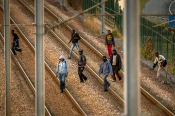 Des migrants sur les rails du site d'Eurotunnel à Coquelles, le 12 août 2015