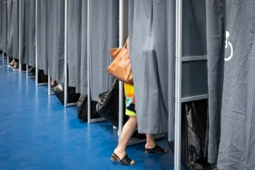 Une électrice entre dans l'isoloir pour voter aux élections européennes à Anse Vata, district de Noumea, en Nouvelle-Calédonie (France), le 9 juin 2024