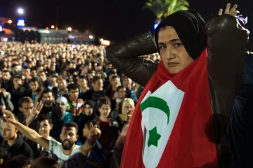 Une manifestante revêt le drapeau berbère en défilant le 30 octobre à Al Hoceima en soutien à un vendeur de poisson, broyé par une benne à ordure