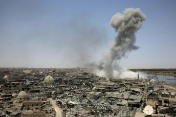 Une colonne de fumée se dégage de la ville irakienne de Mossoul après un raid de la coalition internationale dirigée par les Etats-Unis, en soutien aux forces irakiennes au sol face aux jihadistes, le 9 juillet 2017 