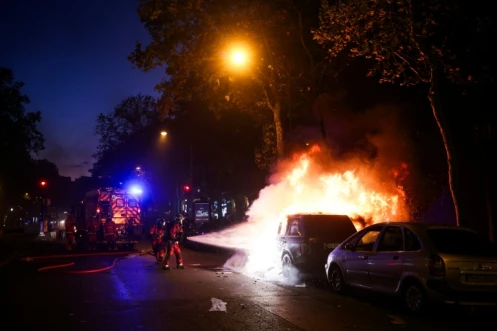 Les pompiers éteignent un véhicule en feu à Paris, lors de la manifestation contre la "vie chère", le 17 octobre 2026