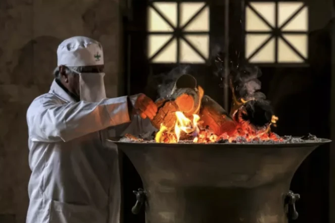 Un prêtre zoroastrien ajoute du bois au feu sacré dans le sanctuaire du temple du feu de Yazd, dans le centre de l'Iran, le 4 juillet 2023 ( AFP / ATTA KENARE )