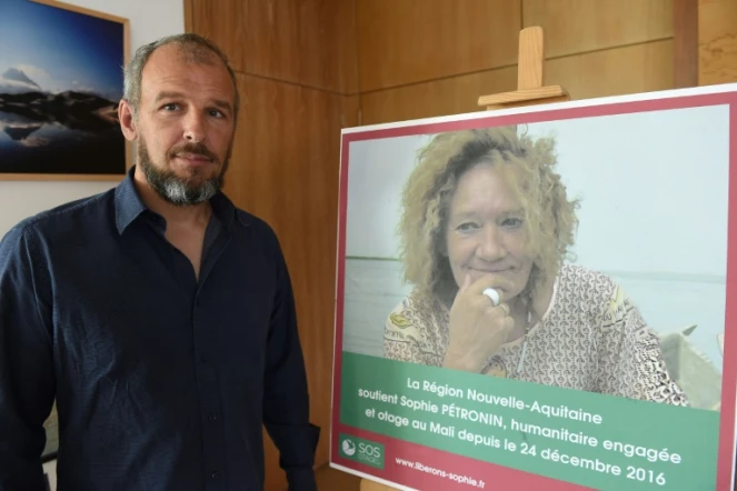 Sébastien Chabaud-Pétronin pose à côté d'une photo de sa mère, Sophie Pétronin, enlevée au Mali en décembre 2016, à Bordeaux, le 29 août 2018