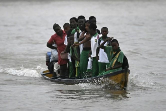 Des étudiants traversent le fleuve Atrato dans un bateau à moteur en bois pour aller étudier dans la municipalité de Quibdo, département de Choco, Colombie, le 30 août 2024 ( AFP / Raul ARBOLEDA )