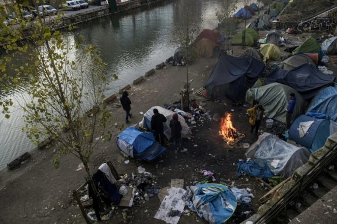 Des migrants se réchauffent autour d'un feu, le 23 février 2018 à Paris où un froid sibérien est attendu