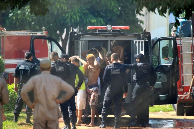 Cette photo fournie par le journal brésilien O Popular montre des gardes ramenant des prisonniers à la prison de l'Etat de Goias, le 1er janvier 2018