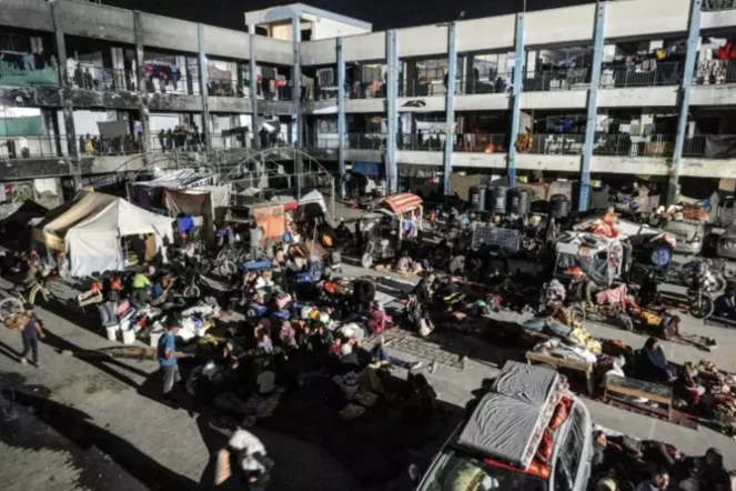 Des Palestiniens déplacés après un ordre d'évacuation israélien à Khan Younès s'apprêtent à passer la buit dans la cour d'une école dans le sud de la bande de Gaza, le 8 août 2024 ( AFP / Bashar TALEB )