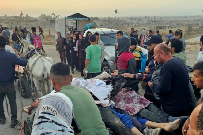 Des Gazaouis évacuent des personnes tuées, selon la Défense civile locale, par des tirs israéliens en marge d'une distribution d'aide à Rafah, dans le sud de la bande de Gaza, le 1er juin 2025