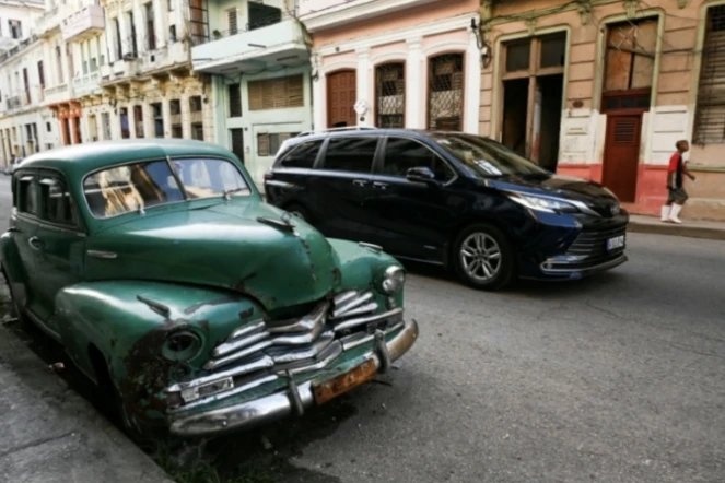 Une vieille voiture américaine (g) et une berline neuve dans une rue de La Havane, le 4 septembre 2024 à Cuba ( AFP / YAMIL LAGE )