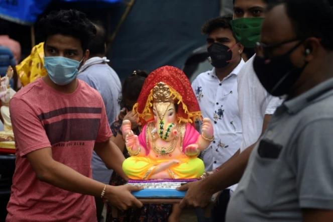 Des fidèles transportent une effigie du dieu hindou à tête d'éléphant au premier jour de la fête de Ganesh à Bombay le 22 aout 2020