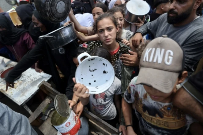 Des enfants se pressent à une distribution de repas chauds à Nousseirat, dans le centre de la bande de Gaza, le 4 juin 2025 ( AFP / Eyad BABA )