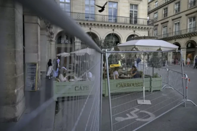 Un café à côté d'une clôture de zone de sécurité à Paris, le 22 juillet 2024 ( AFP / MAURO PIMENTEL )