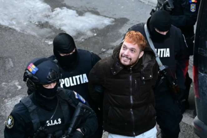 Mohamed Amra escorté par des policiers, le lendemain de son arrestation à Bucarest le 23 février 2025 ( AFP / Daniel MIHAILESCU )