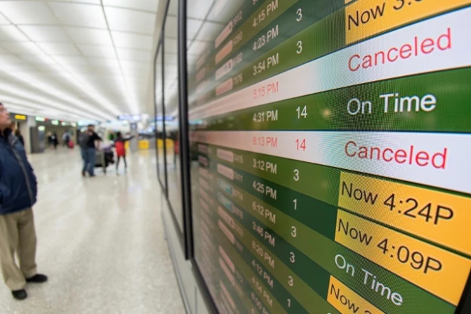 Un tableau d'affichage des vols annulés ou maintenus en raison d'une violente tempête de neige sur le nord-est des Etats-Unis, le 13 mars 2017 à l'aéroport de Dulles, à Chantilly, en Virginie