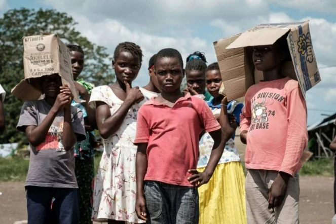 Des enfants assistent le 26 mars 2019 à une distribution d'aide dans la zone d'Estaquinha, au Mozambique, frappée par le cyclone Idai.