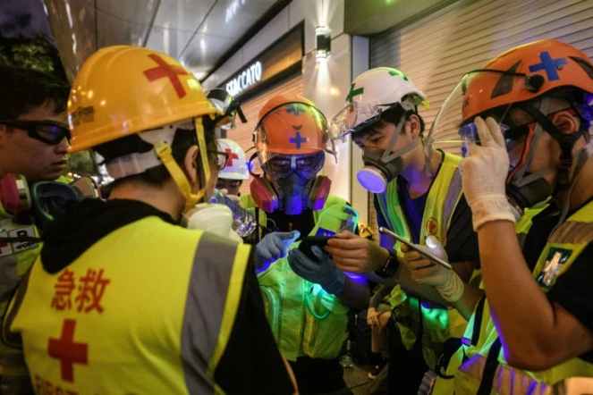 Un groupe de secouristes volontaires coordonnent leur prochaine position lors des manifestations pro-démocratie, le 3 août 2019 à Hong Kong