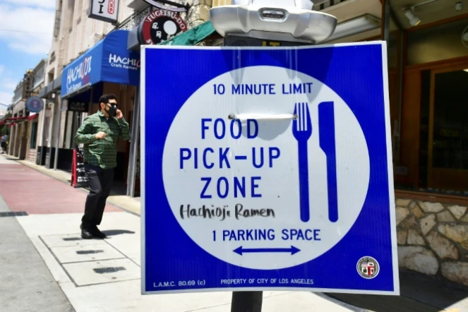 Un panneau devant un restaurant vendant de la nourriture à emporter après la fermeture des salles de restaurant, à Los Angeles le 1er juillet 2020
