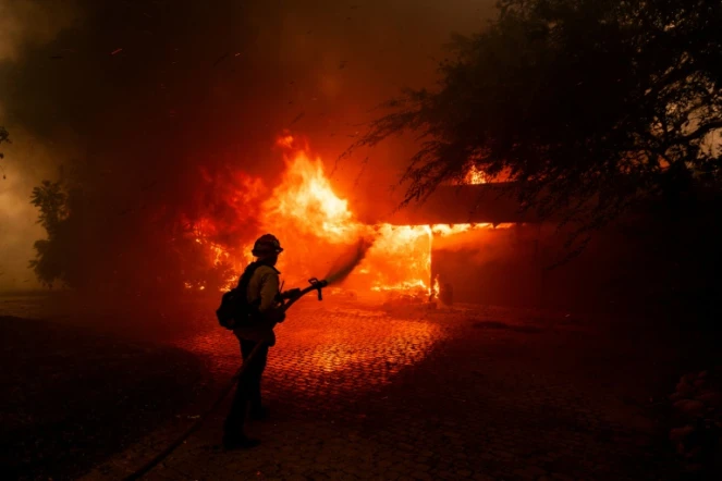 Un pompier lutte contre les flammes du "Mountain Fire", qui engloutissent une maison près de Camarillo, en Californie, le 6 novembre 2024