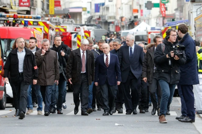 Le ministre de l'Intérieur Bernard Cazeneuve (c) arrive à Saint-Denis à l'issue d'une opération policière antiterroriste en lien avec les attentats de Paris, le 18 novembre 2015
