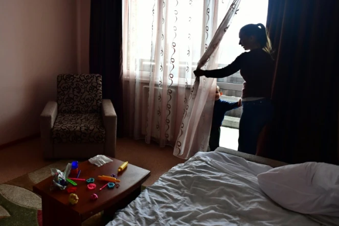 Anna Demkina dans une chambre d'hôtel avec l'un de ses enfants, le 11 janvier 2024 à Belgorod, en Russie