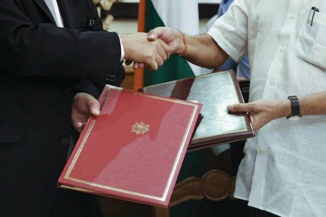 Echange de documents entre le ministre français de la Défense Jean Yves le Drian et son homologue indien Manohar Parrikar après la signature du contrat de vente de Rafale, le 23 septembre 2016 à New Delhi