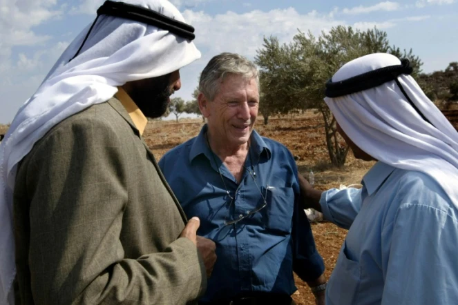 L'écrivain israélien Amos Oz discute avec des Palestiniens après la récolte d'olives à Aqraba, en Cisjordanie, le 30 octobre 2002