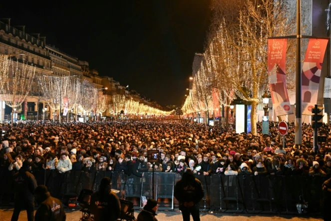 Des personnes se rassemblent sur l'avenue des Champs-Elysées pour les célébrations du Nouvel An à Paris, le 31 décembre 2023