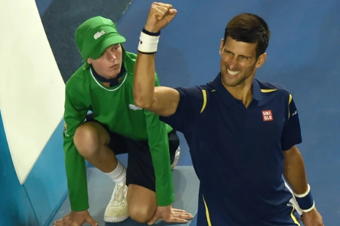 Novak Djokovic lève le bras après avoir éliminé le Japonais Kei Nishikori en quarts de finale à l'Open d'Australie, le 26 janvier 2016 à Melbourne  