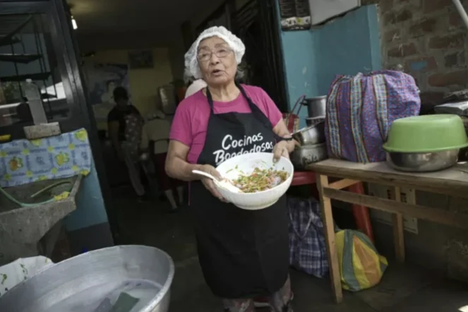 Isabel Santos prépare un plat avec des épluchures de légumes pour tirer le meilleur parti de la nourriture dans une soupe populaire à Lima, le 5 avril 2024 ( AFP / ERNESTO BENAVIDES )