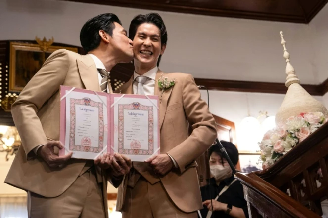 Les acteurs thaïlandais Apiwat "Porsch" Apiwatsayree (gauche) et Sappanyoo "Arm" Panatkool posent après avoir obtenu leur certificat de mariage, le 23 janvier 2025 à Bangkok