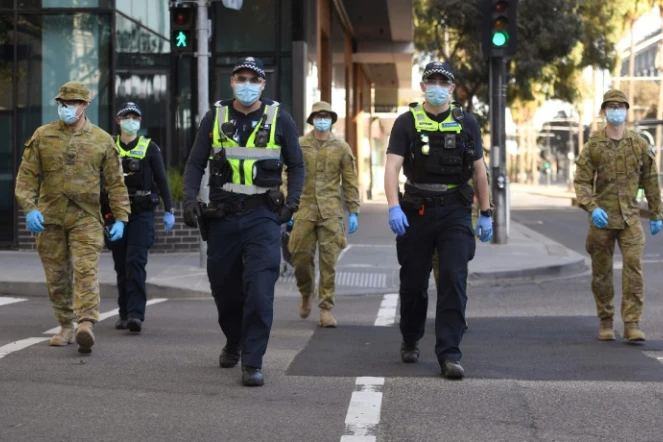 Des policiers et des soldats en patrouille à Melbourne (Australie) le 2 août 2020 après l'instauration d'un couvre-feu en raison du coronavirus