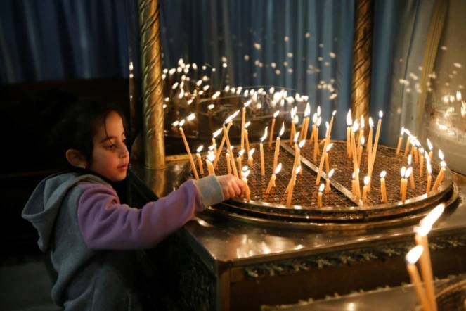 Un enfant allume des bougies à la basilique de la Nativité à Bethléem, en Cisjordanie occupée, le 23 décembre 2019