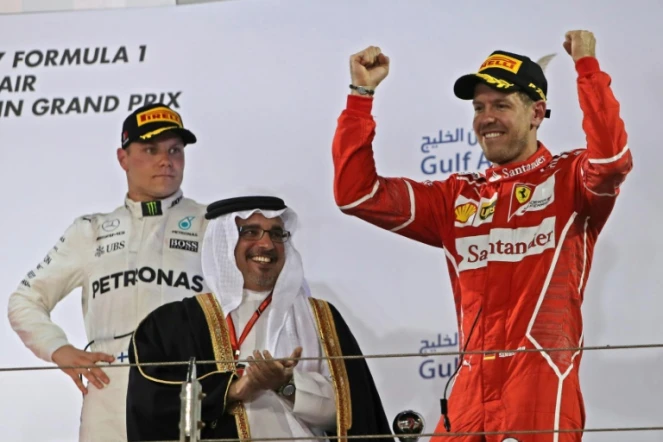 Le pilorte allemand Sebastian Vettel (Ferrari) bras levés sur le podium après sa victoire au Grand Prix de Bahreïn sur le cicuit de Sakhir, le 16 avril 2017