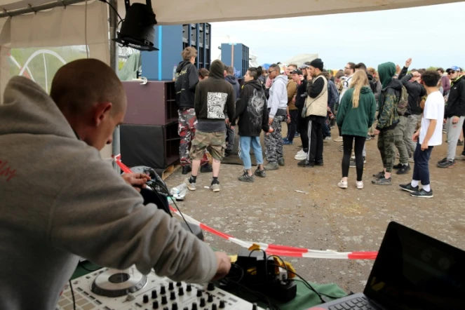 Un DJ aux platines lors de la 25e édition du Teknival organisé sans l'accord des autorités sur l'ancienne base militaire de Marigny dans la Marne, le 28 avril 2018