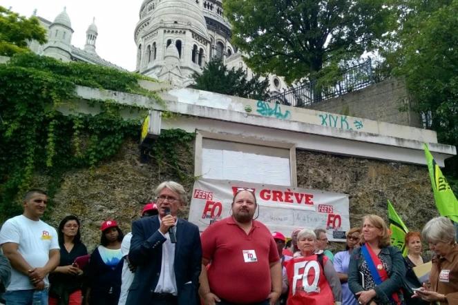 Le Secrétaire général du syndicat FO, Jean-Claude Mailly (g), lors d'une manifestation devant les toilettes publiques de Montmartre à Paris pour défendre les "dames pipi", le 20 août 2015 