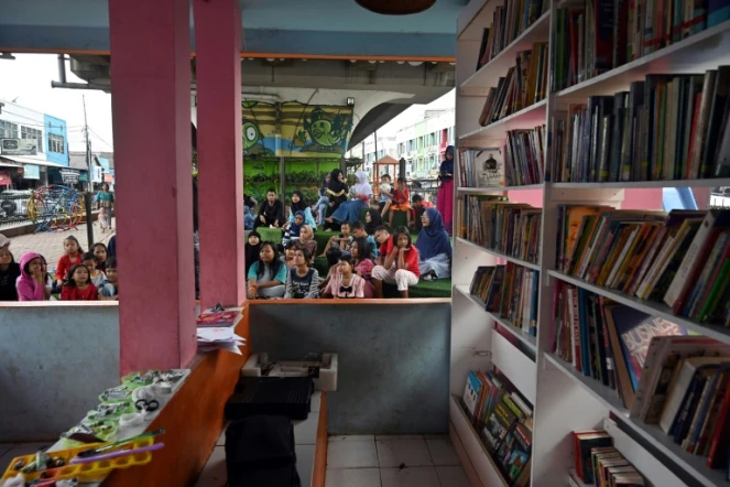 Une bibliothèque de rue installée sous une voie rapide automobile, le 10 février 2019 à Jakarta, en Indonésie